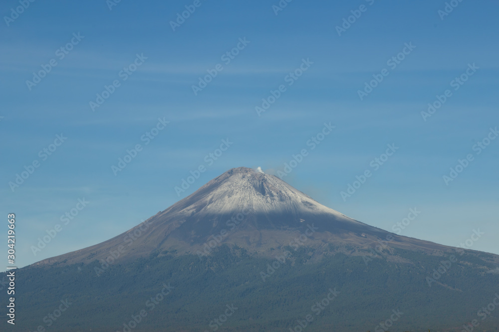 Active volcano Popocatepetl, fumarole over blue sky