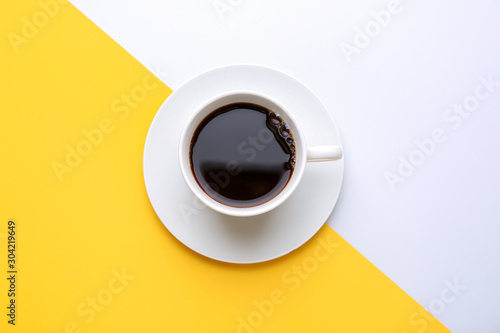 Cup of hot coffee on color background