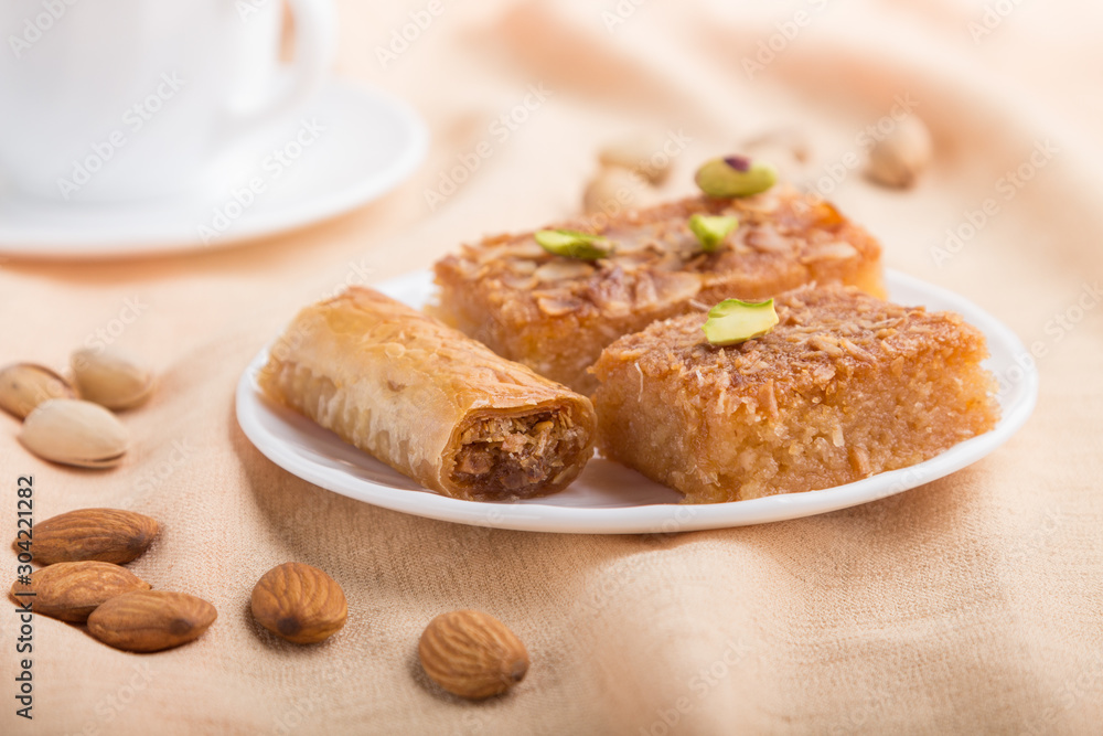 traditional arabic sweets and a cup of coffee on a gray concrete background. side view, selective focus, macro.