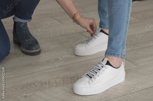 Feet in jeans and white sneakers