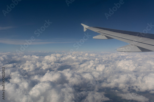 Close Up of Wing of an Airplane Flying on Cloudy Sky Background