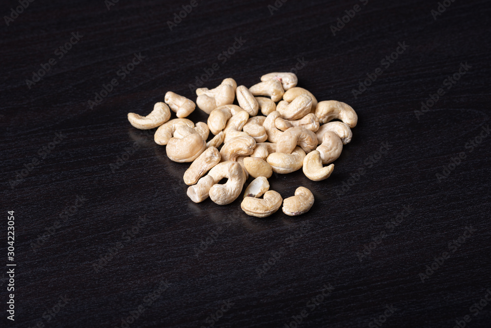 Cashewkerne auf dem schwarzen Holzbrett Cashewkerne auf dem schwarzen Holzbrett