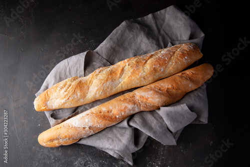 Konstfotografi Fresh hot two baguettes on dark background. Top view.