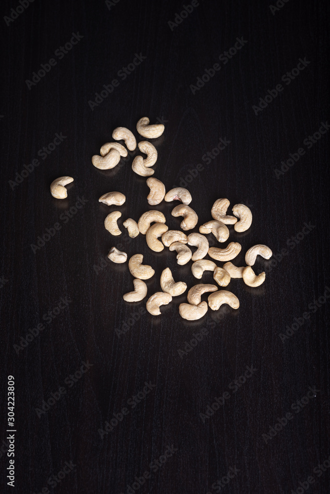 Cashewkerne auf dem schwarzen Holzbrett Cashewkerne auf dem schwarzen Holzbrett