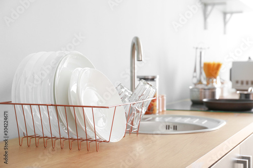 Set of clean dishware near kitchen sink photo