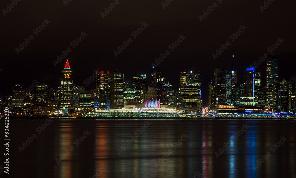 Fototapeta premium The downtown Vancouver skyline at night from North Vancouver. Canada Place and Tower Illuminated with Christmas stile