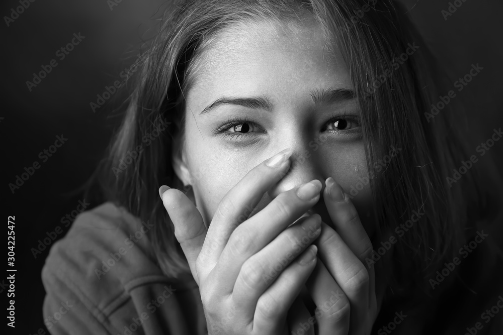 Black and white portrait of sad teenage girl on dark background, closeup Black and white portrait of sad teenage girl on dark background, closeup