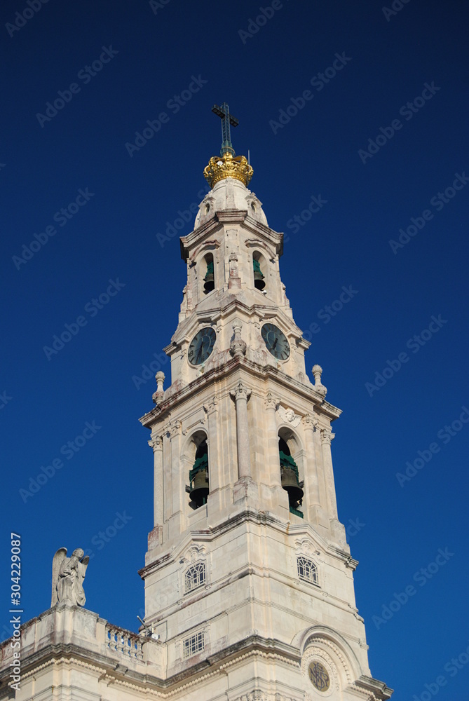 Torre de templo português com relógio, sino, coroa e cruz, Nossa Senhora de Fátima