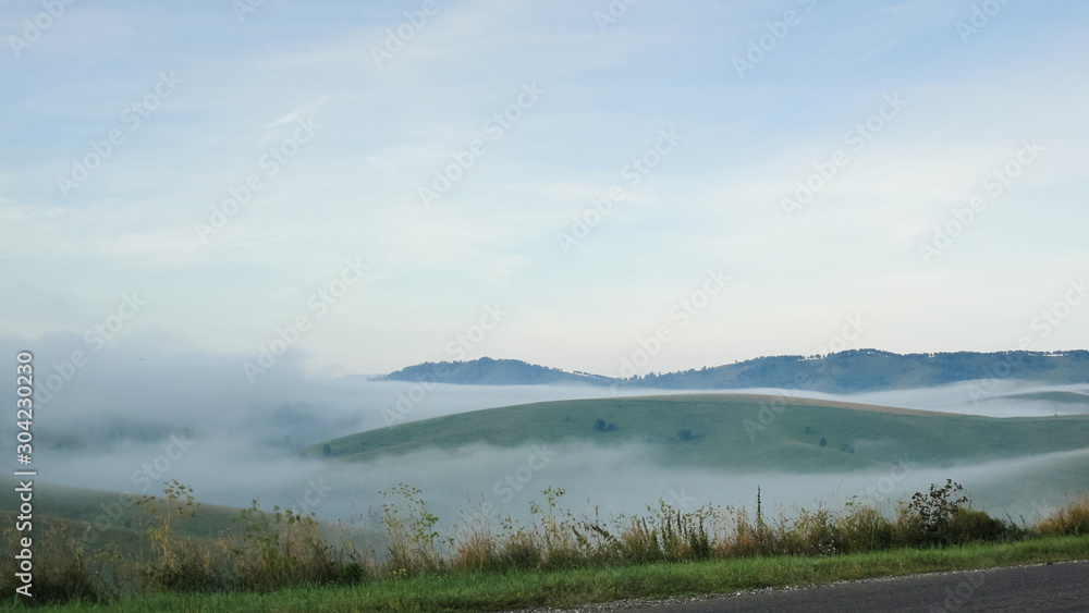 Empty Road with landscape. Mist at asphalt. Fog at highway. Nature in countryside with green hills. Travel and journey. Route in summer. Freeway view with background. Horizon perspective. Outdoor.