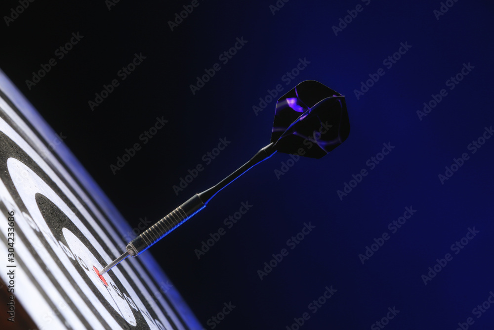 Dartboard with hit bullseye on dark color background, closeup Dartboard with hit bullseye on dark color background, closeup