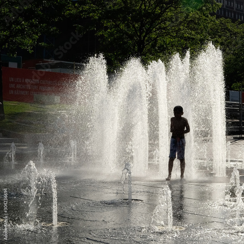 Fototapeta Naklejka Na Ścianę i Meble -  Silhouette of a child having fun in a fountain