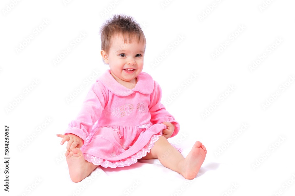 Laughing baby in pink dress holding toes