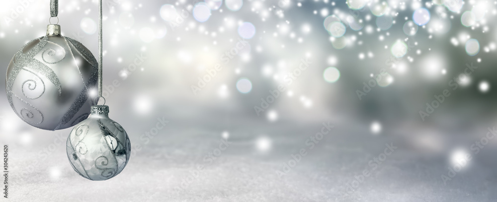 Elegant Christmas background in silver shades, with two baubles hanging and glittering highlights creating a magical atmosphere - obrazy, fototapety, plakaty 