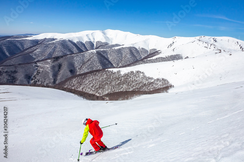 A man is skiing down the hill on the steep slope in Carpathians. Ukraine. High mountain area.