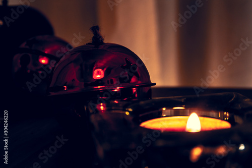 Christmas candles, red apples, cones and spices on rustic wooden background with Balls and Christmas lights. Close up, selective focus 