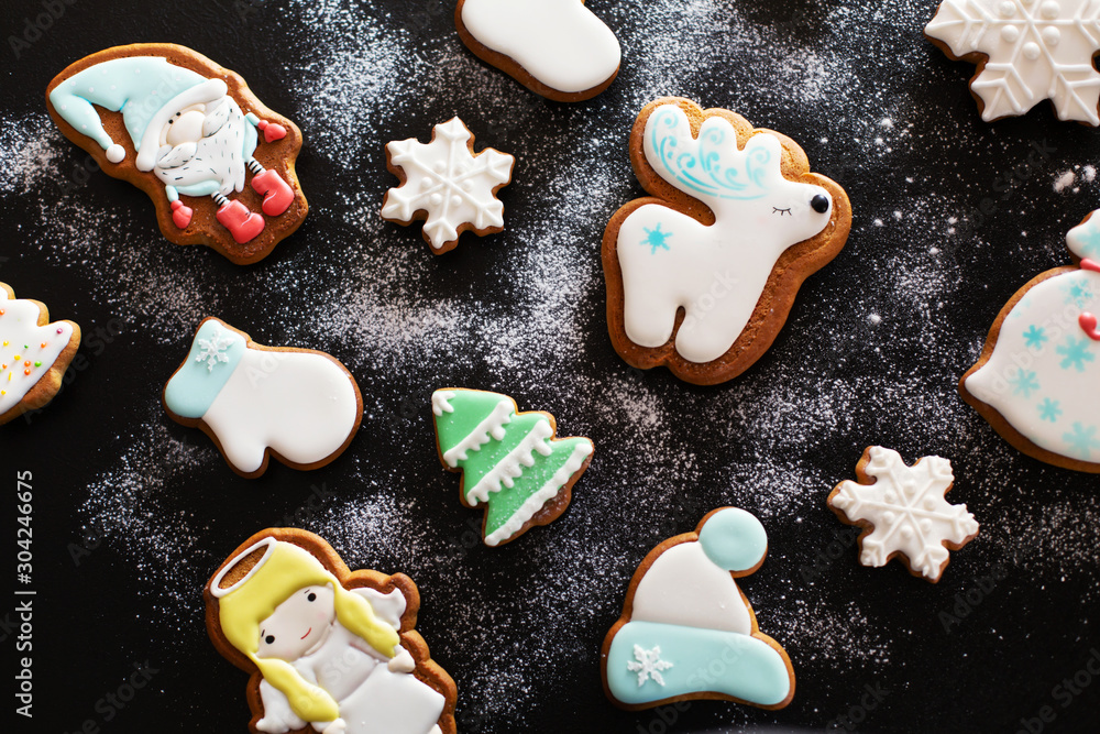 Christmas gift gingerbread on dark background. Christmas gingerbread cookies with icing sugar. Top view Christmas gift gingerbread on dark background. Christmas gingerbread cookies with icing sugar. Top view