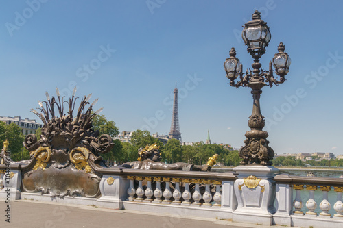 Pont Alexandre III details with the Eiffel Tower in the background, with blue sky
