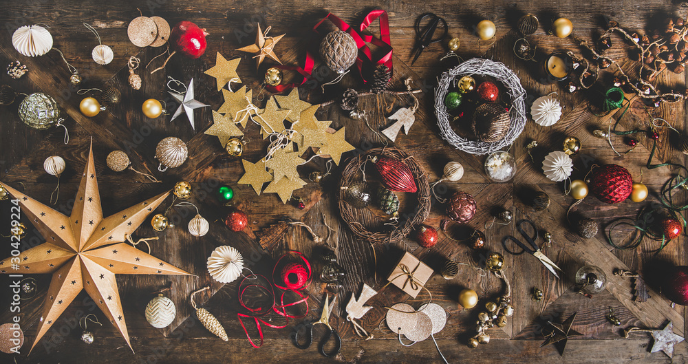 Christmas, New Year holiday layout background, texture, wallpaper. Flat-lay of decorative objects, fur tree toys, garlands, ropes, wreaths over wooden background, top view. Winter holidays preparation - obrazy, fototapety, plakaty 