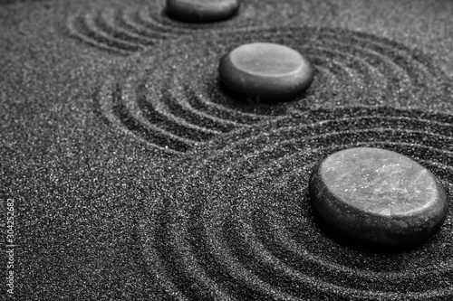 Photography Black sand with stones and beautiful pattern. Zen concept