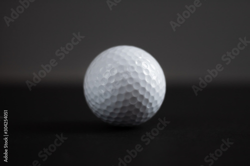 white golf ball on black background copy space