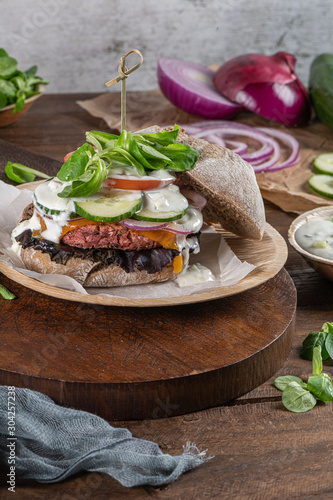 Healthy vegan burger with fresh vegetables and yogurt sauce