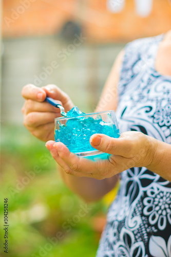 Wallpaper Mural Close of old woman's hands with a jar of desserts in hand eating blue jelly Torontodigital.ca
