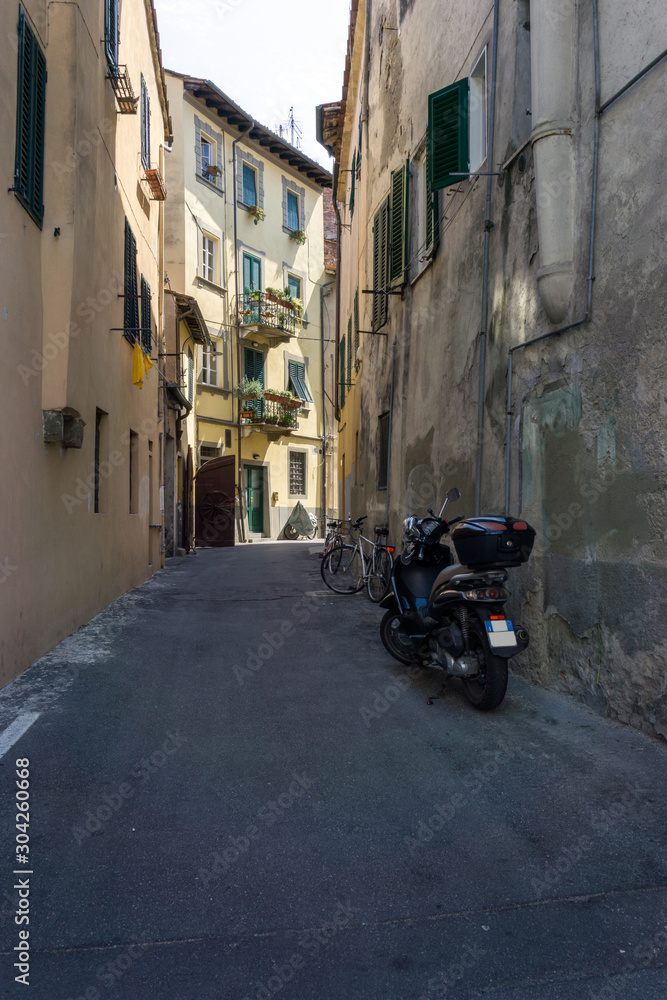 Fototapeta Włoska ulica z zaparkowanymi rowerami i motocyklami