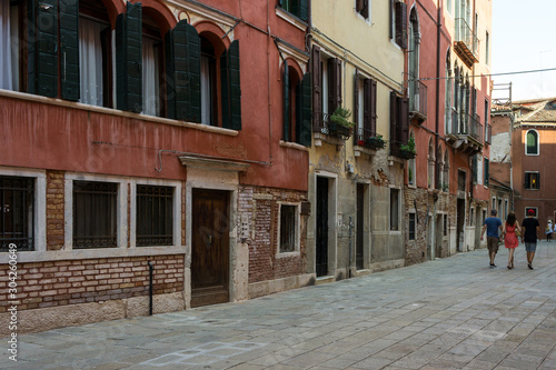 Fototapeta Naklejka Na Ścianę i Meble -  Friends walking down a street in Venice, Italy