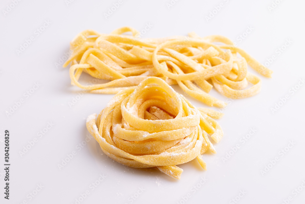 Home made pasta on white background, soft light, copy space Home made pasta on white background, soft light, copy space