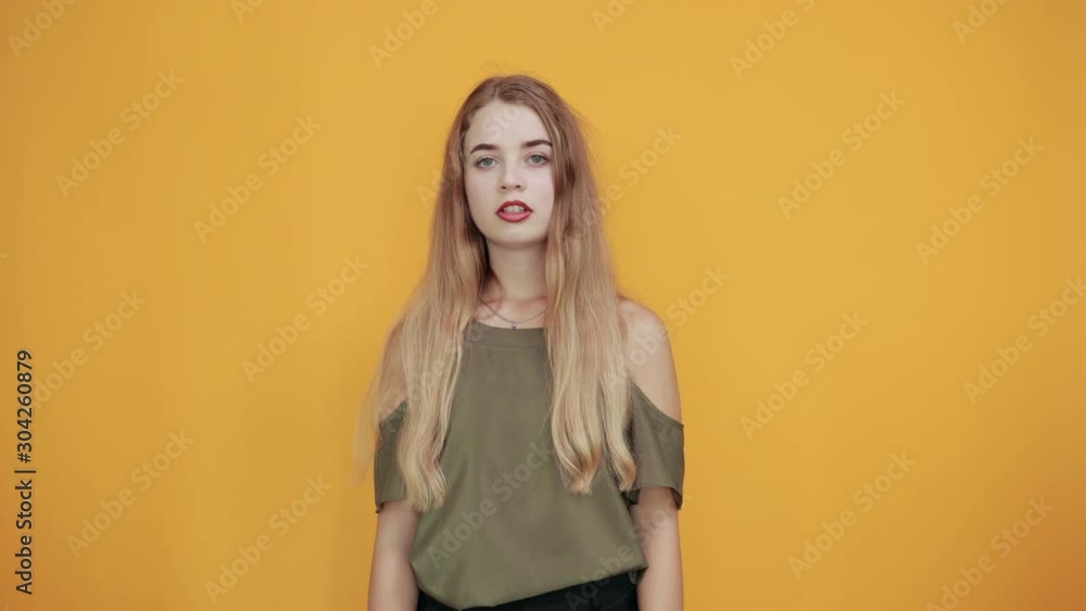 Portrait of scared shocked young woman in casual clothes, rising hands showing palms, stop gesture isolated on orange wall background in studio. People sincere emotions lifestyle concept. Portrait of scared shocked young woman in casual clothes, rising hands showing palms, stop gesture isolated on orange wall background in studio. People sincere emotions lifestyle concept.