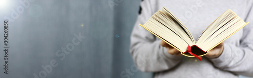 Girl reading an open book. Banner. Blue background.