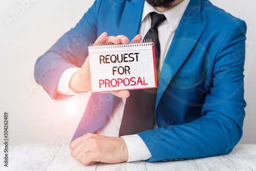 Text sign showing Request For Proposal. Business photo showcasing document contains bidding process by agency or company Man holds empty paper with copy space in front of him Copy Space photo