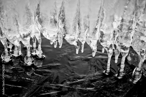 Icicles of dripping water over ice.