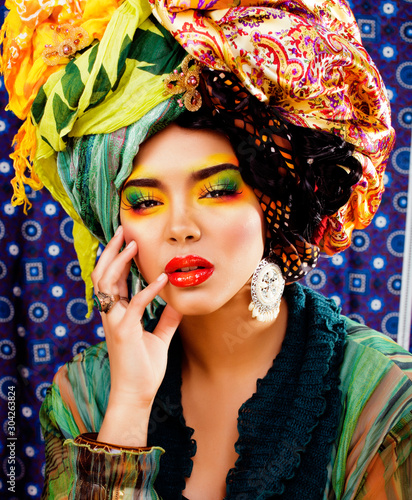 beauty bright woman with creative make up, many shawls on head like cubian, ethno look closeup photo