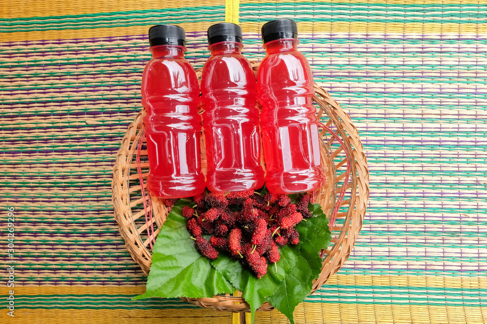 Fototapeta premium Refreshing mulberry juice in the bottles with berries on table, Healthy fruit, Organic fresh.-Healthy concept.