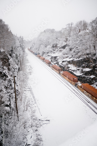 Freight train moving along the tracks in winter.