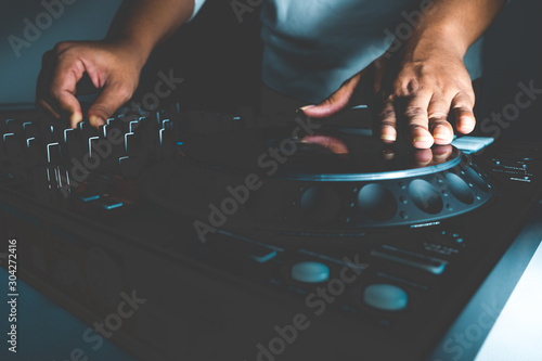 Canvastavla Hands of DJ mixing tracks on professional sound mixer
