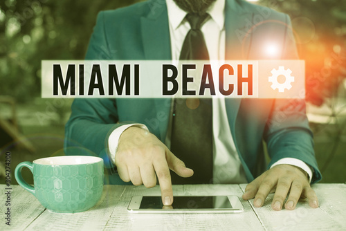 Word writing text Miami Beach. Business photo showcasing the coastal resort city in MiamiDade County of Florida Businessman with pointing finger in front of him photo