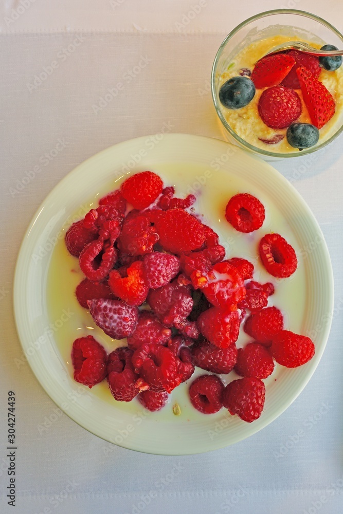 Bowl of fresh red raspberries in milk Bowl of fresh red raspberries in milk