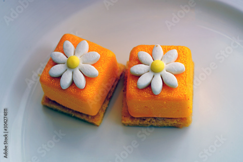 Fotografija Mini petit four bonbon cake with a sugar daisy flower on top