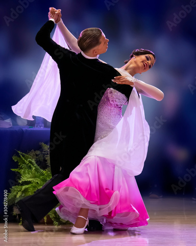 Obraz na plátně A elegant ballroom couple strikes a pose on the dance floor