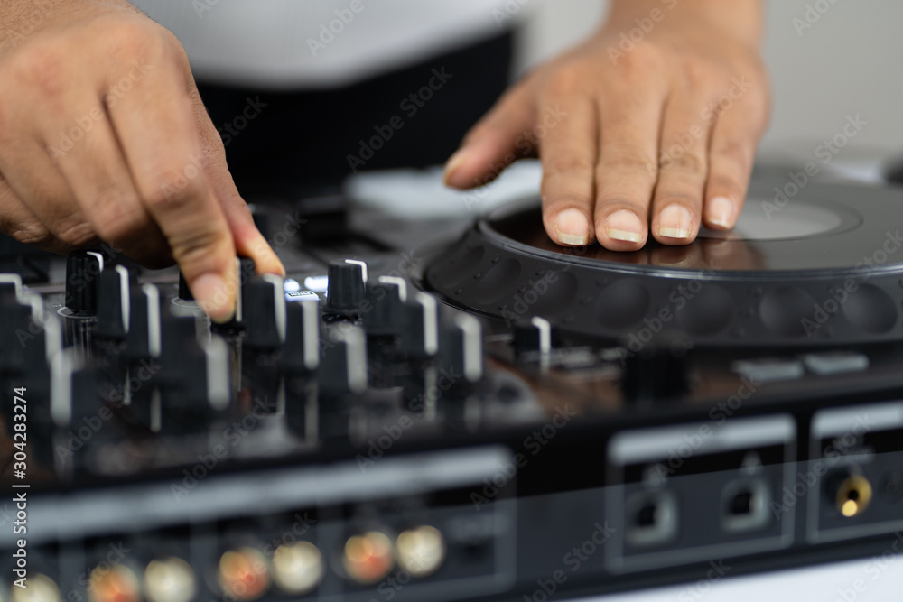 Hands of DJ mixing tracks on professional sound mixer.Fashionable rings on fingers of girl disc jockey playing music.Closeup,knobs and regulators in focus.Girl dj play music tracks at house party Hands of DJ mixing tracks on professional sound mixer.Fashionable rings on fingers of girl disc jockey playing music.Closeup,knobs and regulators in focus.Girl dj play music tracks at house party