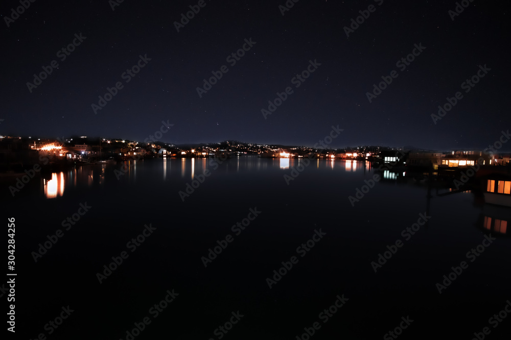 Dusk falls over the houseboats moored at their docks in the marina Sausalito California