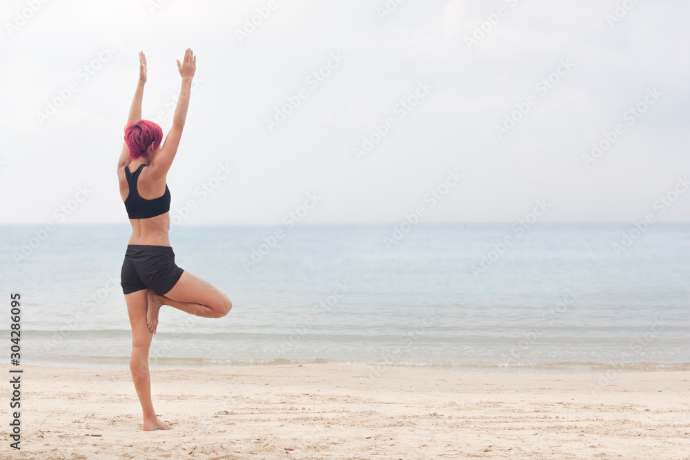 Girl doing yoga on the beach in the early morning Girl doing yoga on the beach in the early morning