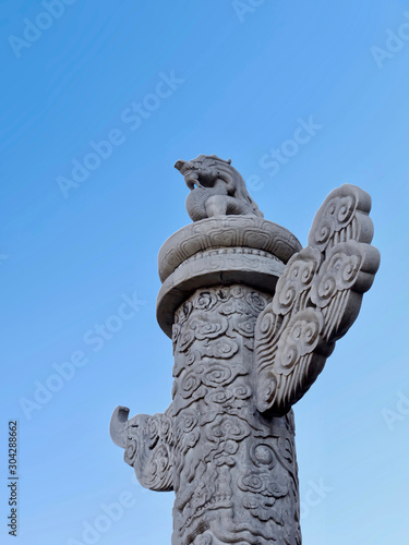 Chinese marble carved columns (Huabiao) against a clear blue sky. columns are installed at the entrance to the Forbidden City. Huabiao is the emblems of traditional Chinese culture. photo