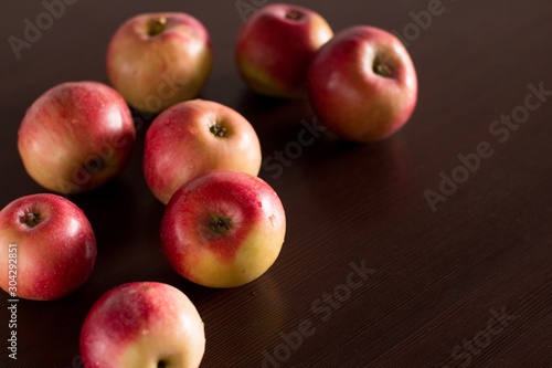 red apples on a dark wooden kitchen table