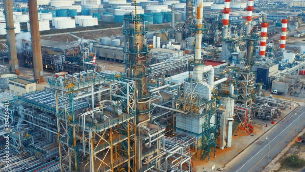 Aerial view of petrochemical oil refinery (refining complex). Oil and gas tanks with fuming pipes on the plant (factory) Aerial view of petrochemical oil refinery (refining complex). Oil and gas tanks with fuming pipes on the plant (factory)