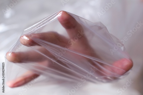 young womans hand covered in transparent air bubble plastic wrap photo