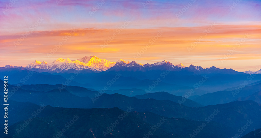 Sunrise brings all the colours of the world and lays golden layer on the snowy mountains