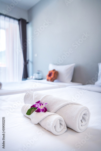 Towel with Orchid on bed decoration in bedroom interior for hotel customer.